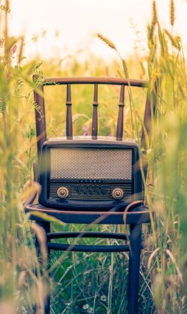 image de radio ancienne posee sur une chaise en exterieur